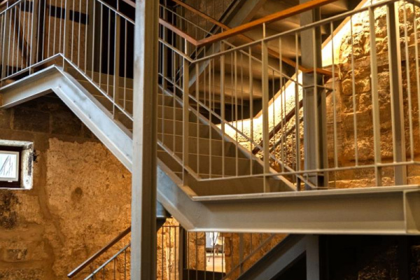 Die Verbindung von historischem Charme und modernem Stil zeigt sich eindrucksvoll im Treppenaufgang zu den Apartments.