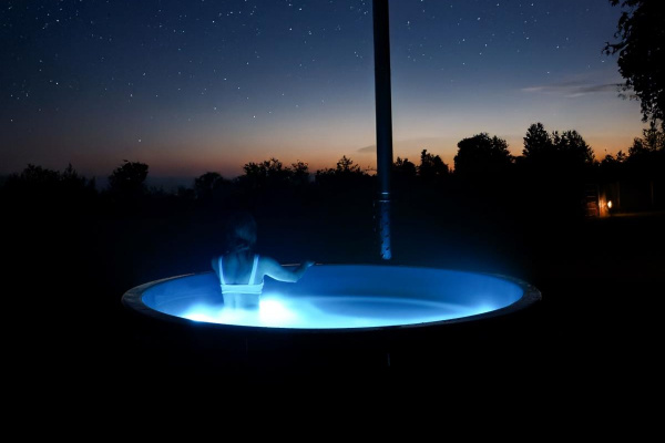 Hinter der Remise steht der Hot Tube mit Blick über die Wiesen und Felder