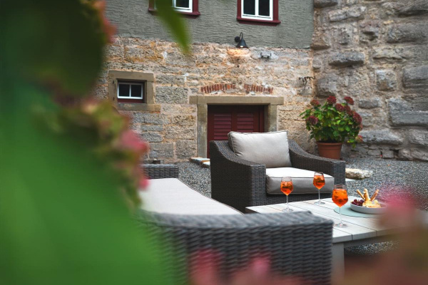 Unser großzügiger Außenbereich bietet ebenfals Loungemöbel, einen Grill, zwei große Esstische und jede Menge Platz zum Toben und Entspannen.