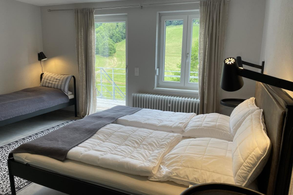 Schlafzimmer unten links – direkter Gartenzugang und zusätzliches Einzelbett.